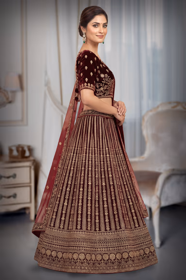 Luxurious Deep Maroon Velvet Lehenga Set Showcasing Detailed Gold Zari Work And A Sheer Net Dupatta For A… — view 3 of 3